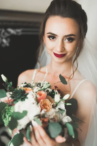 Bela noiva vestindo vestido de noiva de moda com penas com deleite de luxo maquiagem e penteado, estúdio sessão de fotos indoor — Fotografia de Stock