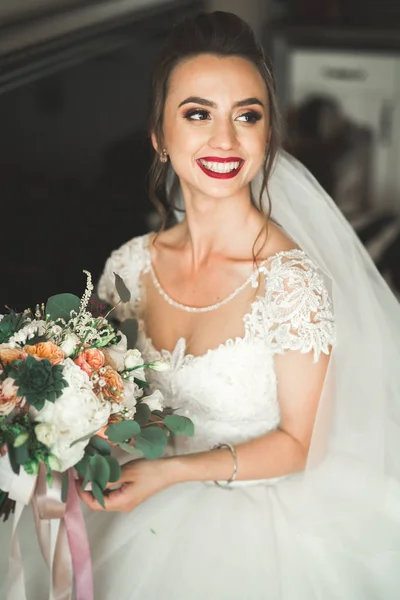 Hermosa novia con vestido de novia de moda con plumas con maquillaje de lujo deleite y peinado, estudio sesión de fotos interior —  Fotos de Stock