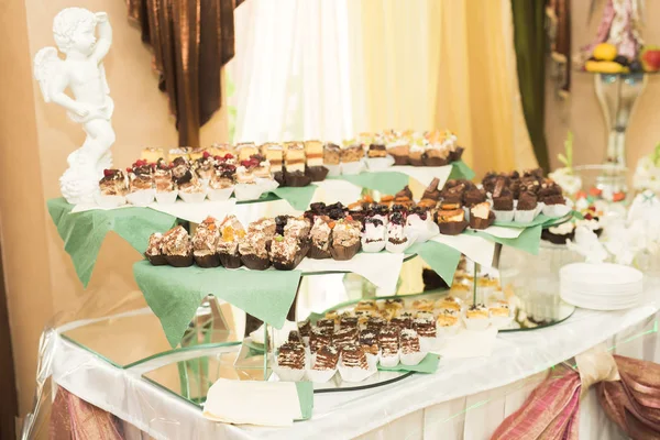 Delicious and tasty dessert table with cupcakes shots at reception closeup — Stock Photo, Image