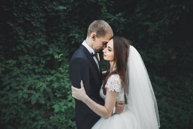 Yeni evli çift el ele tutuşurken parkta koşup zıplıyorlar.