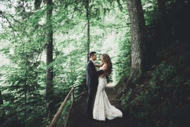 Yeni evli çift el ele tutuşurken parkta koşup zıplıyorlar.