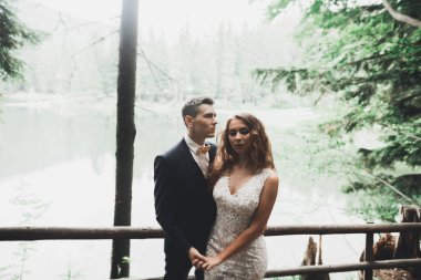 Yeni evli çift el ele tutuşurken parkta koşup zıplıyorlar.