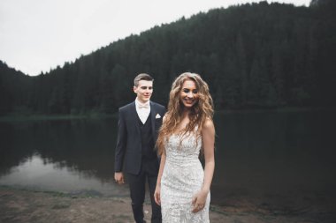 Harika bir gelin damada poz veriyor ve harika manzaralı dağlarda lüks bir tören yapıyor.