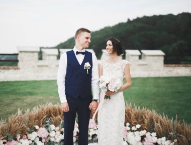 Güzel, mutlu bir düğün çifti, güzel şehirde uzun beyaz elbiseli bir gelin.