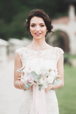 Gelinlik içinde dışarıda poz veren güzel gelin.