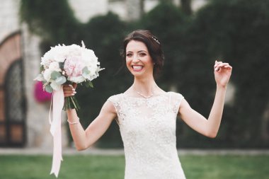 Gelinlik içinde dışarıda poz veren güzel gelin.