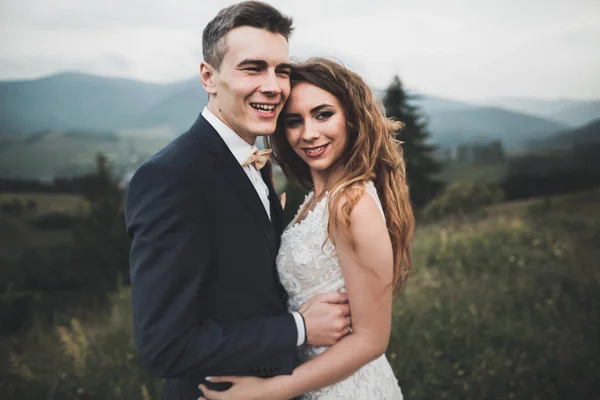 Casal feliz posando sobre bela paisagem nas montanhas — Fotografia de Stock