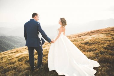 Harika bir gelin damada poz veriyor ve harika manzaralı dağlarda lüks bir tören yapıyor.