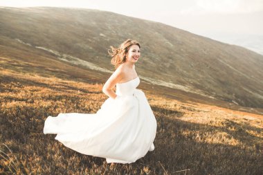 Gün batımında dağ zemin üzerine bir buket ile güzel gelin