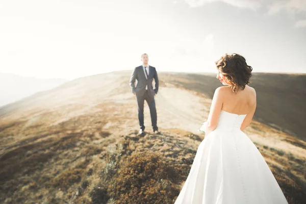 Glücklich schönes Hochzeitspaar Braut und Bräutigam am Hochzeitstag im Freien auf dem Bergfelsen. Glückliches Ehepaar im Freien in der Natur, weiches Sonnenlicht — Stockfoto