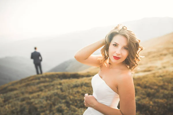 Fiatal házaspár, menyasszony és vőlegény csók, ölelés tökéletes kilátás nyílik a hegyekre, kék ég — Stock Fotó
