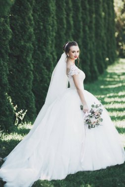 Gelinlik içinde dışarıda poz veren güzel gelin.