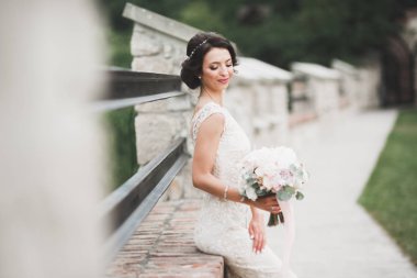 Parkta poz veren gelinlikli güzel, lüks bir gelin.