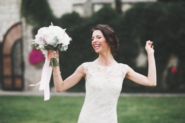 Parkta poz veren gelinlikli güzel, lüks bir gelin.