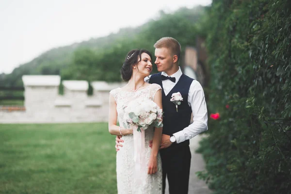 Preciosa pareja feliz boda, novia con vestido blanco largo posando en la hermosa ciudad —  Fotos de Stock