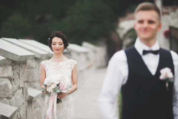 Lovely happy wedding couple, bride with long white dress posing in beautiful city — Stock Photo, Image
