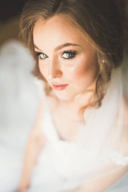 Beyaz elbiseli lüks gelin düğün törenine hazırlanırken poz veriyor.