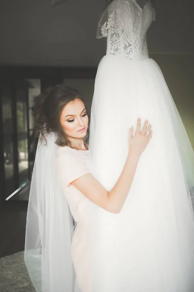 Linda noiva em roupão posando e se preparando para o rosto cerimônia de casamento em uma sala — Fotografia de Stock