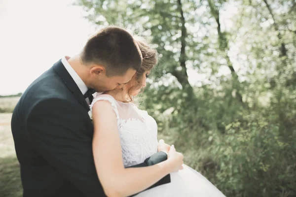 Happy wedding couple walking in a botanical park — Stock Photo, Image