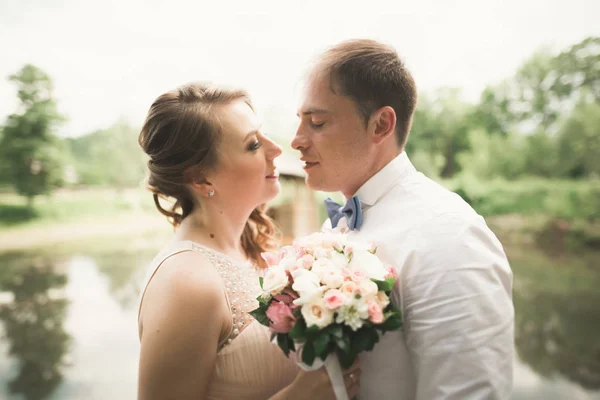 Casal feliz abraçando e sorrindo um ao outro no lago de fundo, floresta — Fotografia de Stock