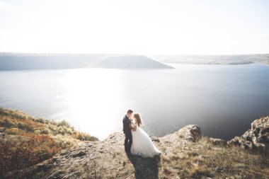 Güzel bir sahilde poz veren genç bir çiftin mutlu ve romantik sahnesi.