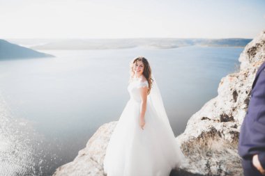 Güzel bir sahilde poz veren genç bir çiftin mutlu ve romantik sahnesi.