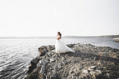 Arka planda beyaz elbiseli romantik gelin pozu