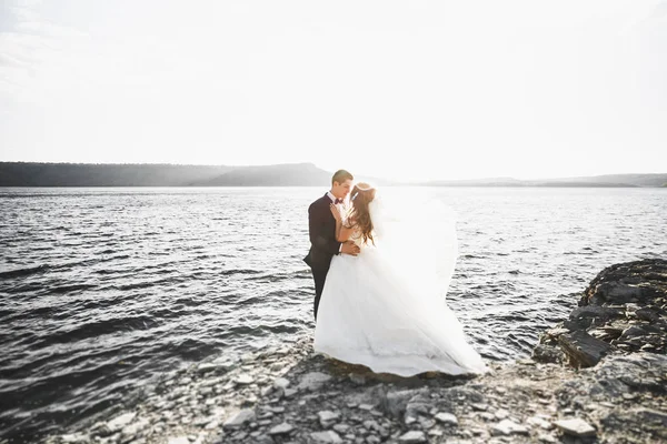 Élégant couple de mariage heureux élégant, mariée, marié magnifique sur le fond de la mer et le ciel — Photo