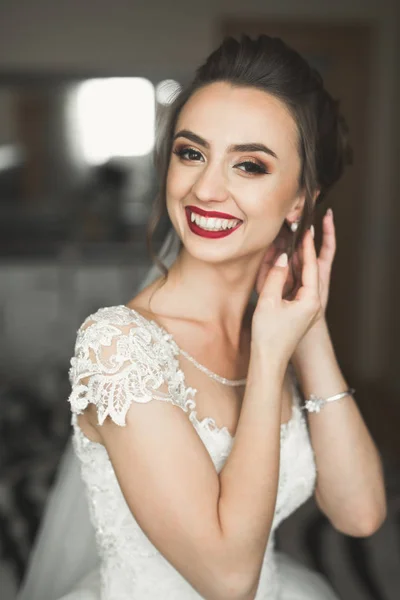 Hermosa novia con vestido de novia de moda con plumas con maquillaje de lujo deleite y peinado, estudio sesión de fotos interior —  Fotos de Stock