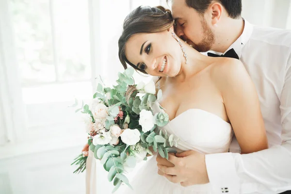 Gyönyörű vőlegény gyengéden átölelve stílusos menyasszony. Érzéki pillanat luxus esküvői pár — Stock Fotó