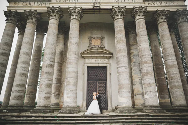 Hermosa pareja de recién casados cuento de hadas abrazándose cerca del antiguo castillo medieval —  Fotos de Stock