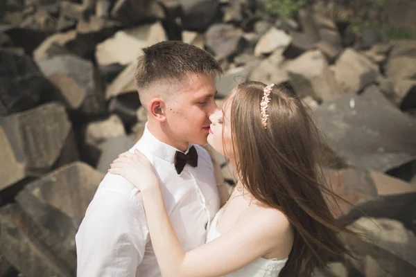 Ślub para w miłości całowanie i przytulanie w pobliżu skał na pięknym krajobrazie — Zdjęcie stockowe