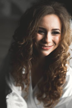 Cüppeli muhteşem gelin bir odada düğün töreni için poz veriyor ve hazırlanıyor.