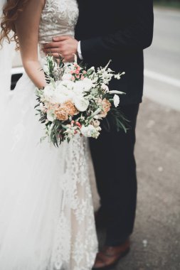 Elinde farklı çiçekler olan güzel bir düğün buketi.