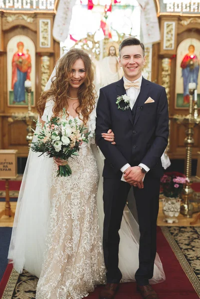 Супружеская пара позирует в церкви после церемонии — стоковое фото