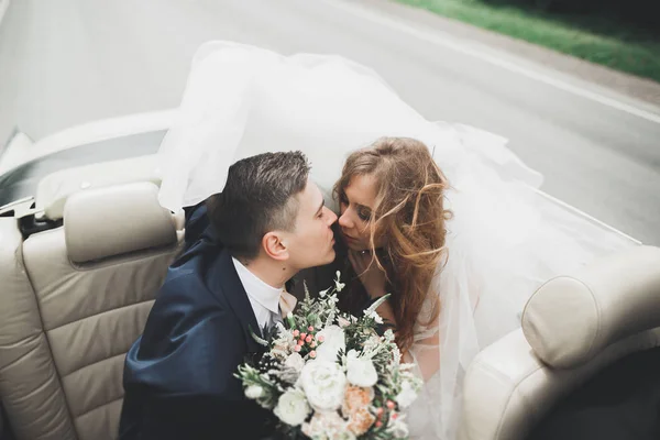 Pareja recién casada en el lujoso coche retro el día de su boda —  Fotos de Stock