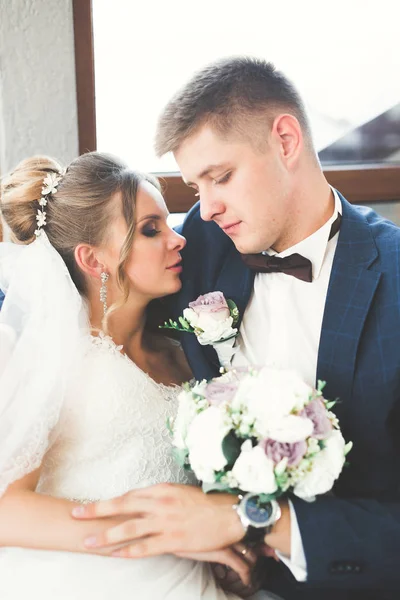 Casal feliz encantador do casamento, noiva com vestido branco longo posando na cidade bonita — Fotografia de Stock