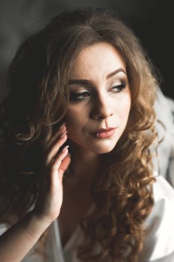 Cüppeli muhteşem gelin bir odada düğün töreni için poz veriyor ve hazırlanıyor.