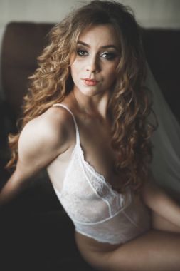 Beyaz elbiseli lüks gelin düğün törenine hazırlanırken poz veriyor.