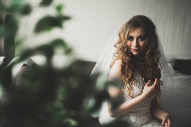 Beyaz elbiseli lüks gelin düğün törenine hazırlanırken poz veriyor.