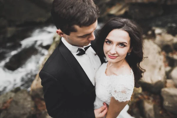 Hochzeitspaar, Bräutigam und Braut umarmen sich, im Freien am Fluss — Stockfoto