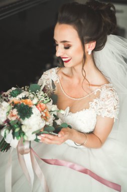 Beyaz elbiseli lüks gelin düğün törenine hazırlanırken poz veriyor.