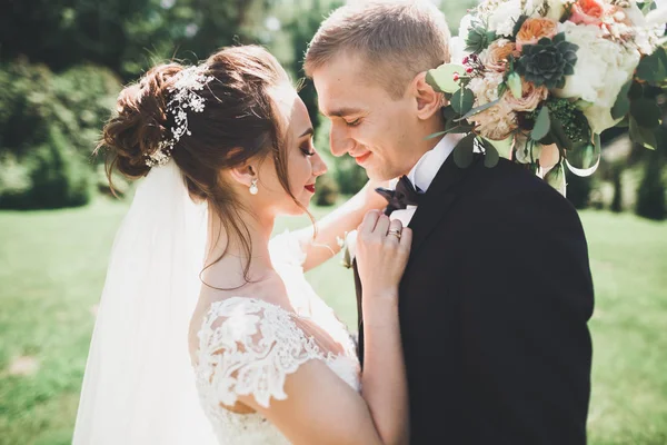 Beau jeune couple de mariage s'embrasse et sourit dans le parc — Photo