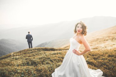 Harika bir gelin damada poz veriyor ve harika manzaralı dağlarda lüks bir tören yapıyor.