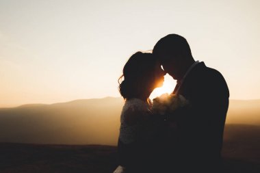 Düğün gününde damadın ve gelinin dağların eteklerinde mutlu mesut evlenecekler. Doğada mutlu evlilikler, yumuşak güneşli ışıklar.