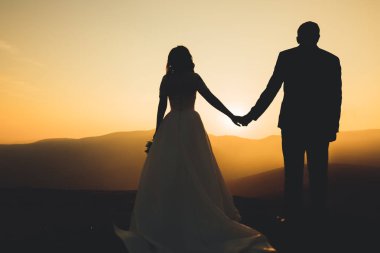 Düğün gününde damadın ve gelinin dağların eteklerinde mutlu mesut evlenecekler. Doğada mutlu evlilikler, yumuşak güneşli ışıklar.