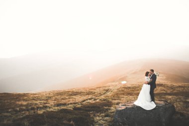 Harika bir gelin damada poz veriyor ve harika manzaralı dağlarda lüks bir tören yapıyor.
