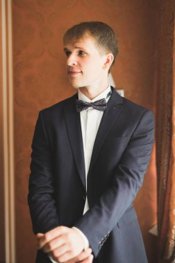 Güzel adam, damat poz veriyor ve düğüne hazırlanıyor.