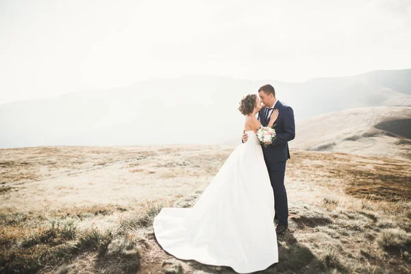 Casal feliz posando sobre bela paisagem nas montanhas — Fotografia de Stock