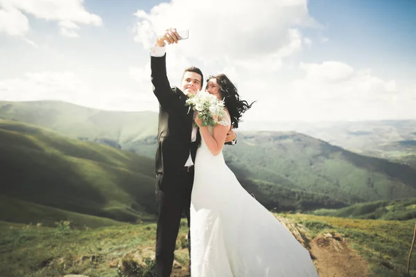 Просто женатая пара на вершине горы, фотографирующая селфи — стоковое фото